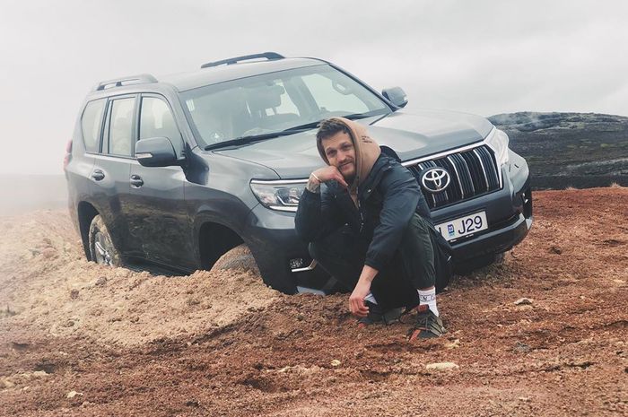 Alexander Tikhomrov berpose dengan Toyota Land Cruiser miliknya yang ambles saat off-roading.
