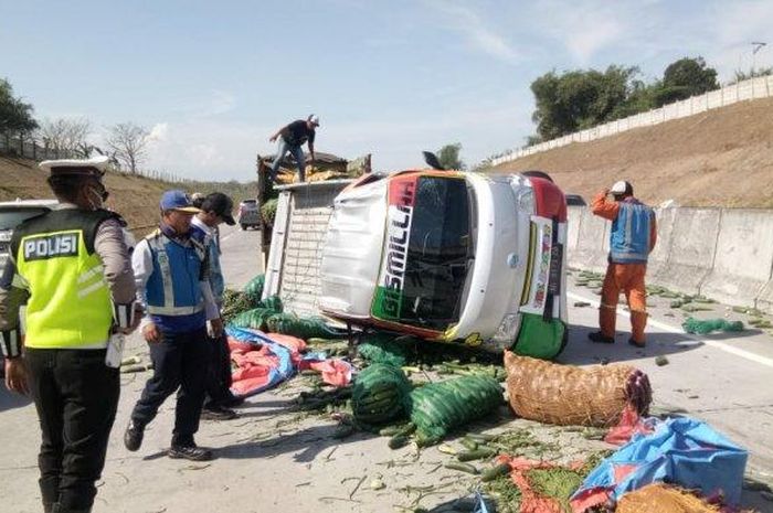 Petugas PJR Ditlantas Polda Jatim dan Jasa Marga mengevakuasi pikap muatan sayur yang terguling di jalan tol Warugunung Surabaya.  