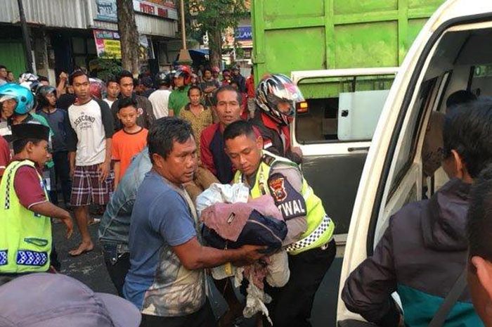 Petugas kepolisian bersama warga melakukan evakuasi korban kecelakaan yang melibatkan mahasiwa, Kamis (20/6/2019)  