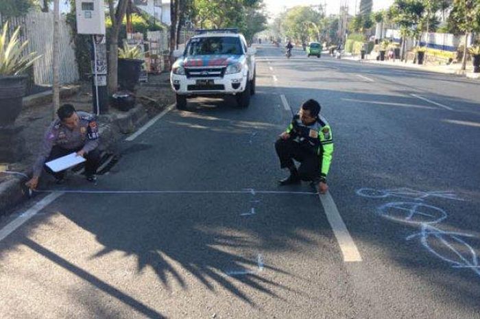 Petugas kepolisian melakukan olah TKP kejadian kecelakaan di Jalan Trunojoyo, Kelurahan Songgokerto, Jumat (21/6). 