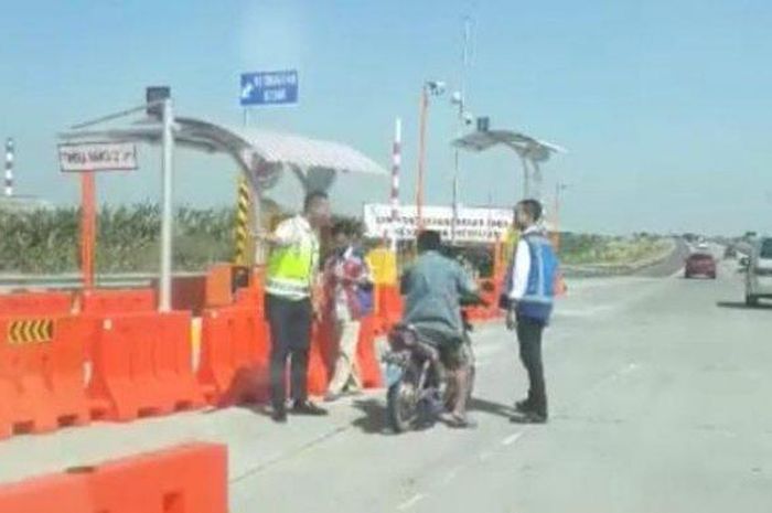 Petugas mencegat pengendara sepeda motor Honda Supra yang nekat masuk ke Tol Warugunung, Sidoarjo.  