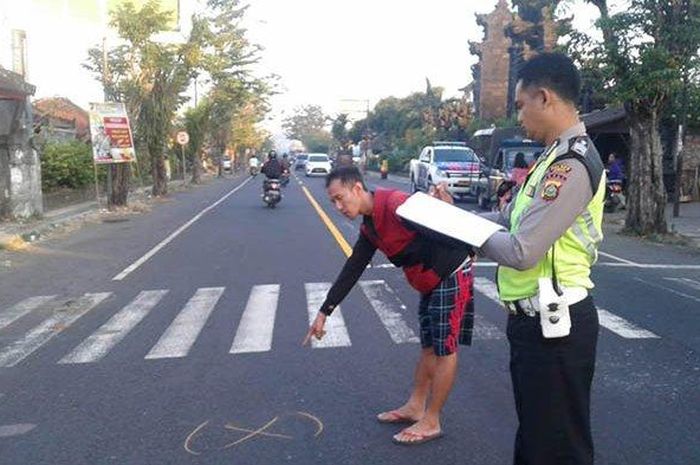 Petugas kepolisian melakukan olah tempat kejadian perkara di lokasi kecelakaan di Lingkungan Delod Bale Agung Kelurahan Tegalcangkring, Kecamatan Mendoyo, Minggu (7/7/2019).  