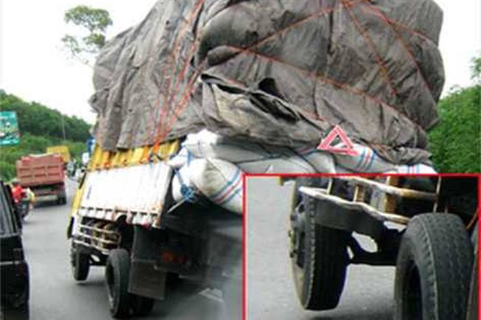 Ilustrasi truk overload ban depan  mengangkat.
