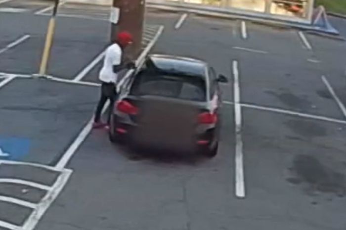 Pencuri sedang mencoba mencuri mobil sedan BMW hitam di Atlanta, AS
