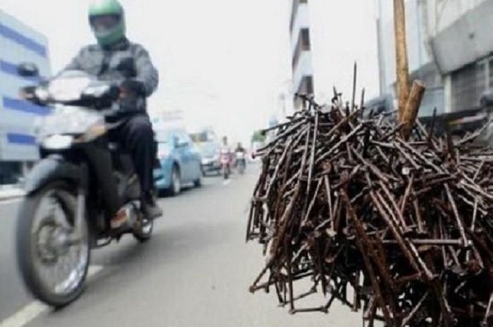 Ilustrasi ranjau paku di jalan raya.