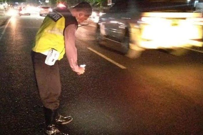 Polisi yang tengah memeriksa jalan yang menjadi lokasi tabrakan ibu hamil dengan Kawasaki Ninja 250.