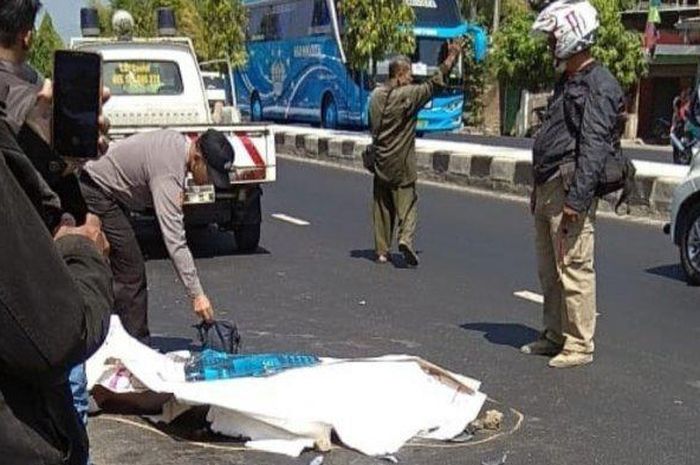 Petugas kepolisian saat mengevakuasi jenazah pengendara Yamaha NMAX di Jalan Raya Solo - Yogyakarta tepatnya di utara Balai Desa Tempel, Gatak, Senin (29/7/2019).  