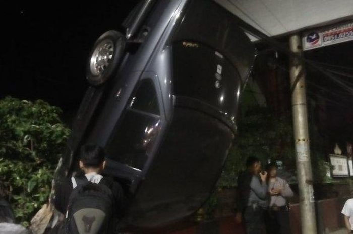 Mobil BMW nyangkut di tembok pemakaman samping Underpass Unila dalam kondisi terbalik. Lakalantas antara BMW dengan Avanza terjadi di dekat Underpass Unila, Jumat (2/8/2019) sekitar pukul 00.30 dini hari. 