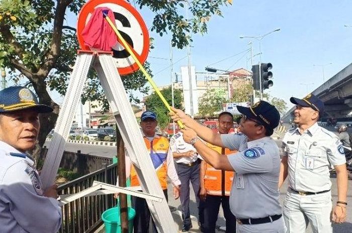 Aksi bersih-bersih rambu lalu lintas di Jalan Jamin Ginting, Medan (13/8/2019).  