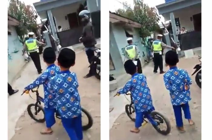 Para warga menyaksikan polisi melakukan razia di gang sempit jalan kampung