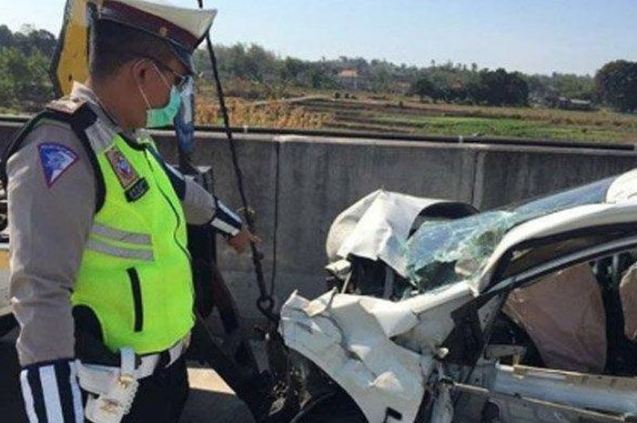 Petugas menunjukkan kondisi mobil Honda Brio yang ringsek bagian depannya seusai menabrak bagian belakang truk tangki di Tol Sumo, Senin (2/9/19).  