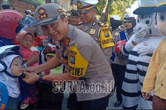 Kapolres Madiun, AKBP Ruruh Wicaksono, memberikan helm SNI kepada pengendara. 