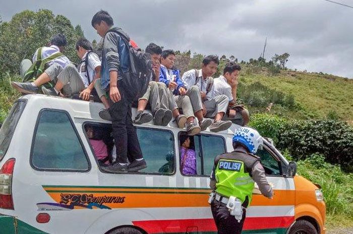 Para pelajar yang naik di atas kap angkot kocar-kacir turun saat didatangi polisi, Rabu (4/9/2019) di kawasan Kecamatan Parbuluan, Kabupaten Dairi. Mereka ketakutan lantaran mengira akan ditangkap. 