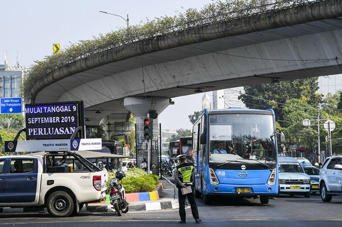 Petugas kepolisian mengatur lalulintas saat hari pertama penindakan sistem ganjil-genap di kawasan Matraman, Jakarta, Senin (9/9/2019). Petugas kepolisian mulai memberlakukan penindakan berupa tilang terhadap pengendara mobil yang melanggar di kawasan perluasan sistem ganjil-genap. ANTARA FOTO/Galih