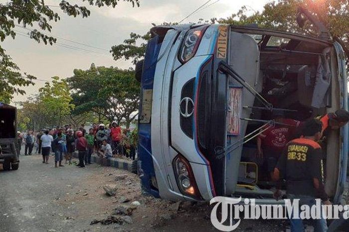 Kondisi Bus PO Sugeng Rahayu yang terguling setelah menabrak motor Honda Vario yang menyebrang liar di Jalan Ring Road Kota Madiun, Selasa (24/9/2019)