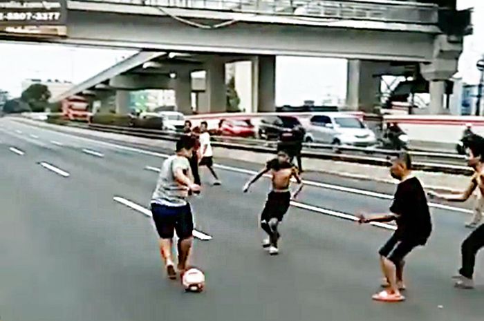 Anak-anak bermain bola di tol dalam kota