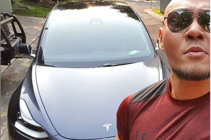 Deddy Corbuzier berfoto dengan mobil Tesla Model 3 miiknya