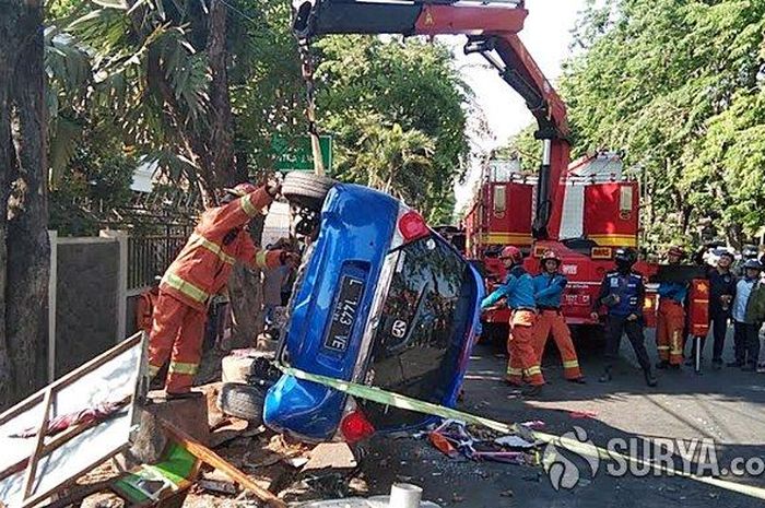 Sebuah mobil Honda Brio sedang dibantu petugas damkar setelah menabrak gerobak bakso