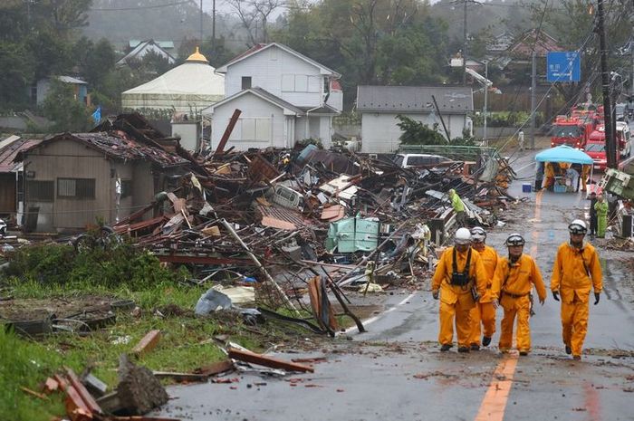 Sekelompok pekerja penyelamat melewati rumah yang hancur akibat terjangan Topan Hagibis di Ichihara, Prefektur Chiba, pada 12 Oktober 2019. Topan Hagibis, dikenal juga sebagai Topan Nomor 19, disebut adalah topan terkuat yang melanda Jepang dalam 60 tahun terakhir.