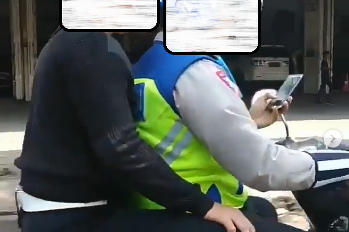 Polisi bermain ponsel saat berkendara sambil membawa penumpang tak pakai helm