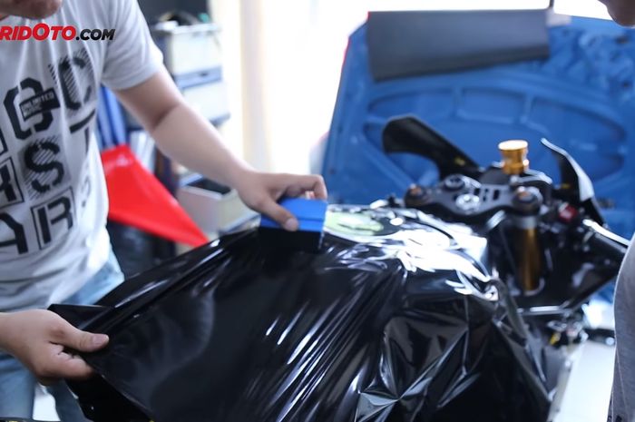 Ilustrasi pemasangan stiker di bodi motor