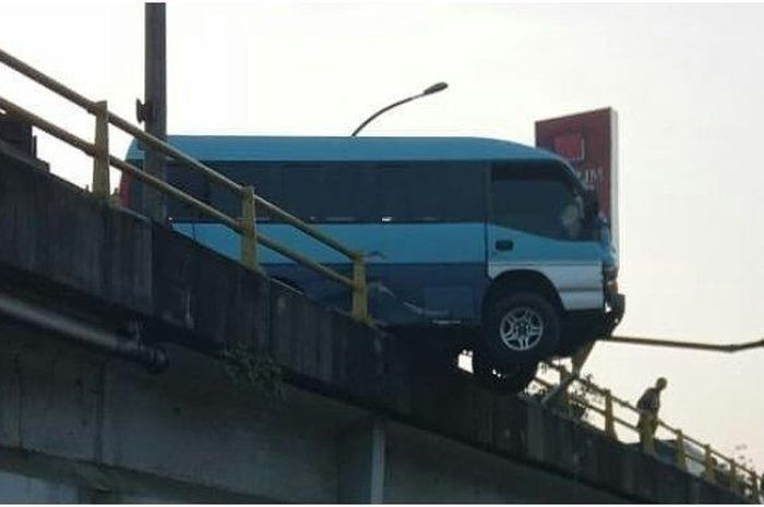 Belum jelas sebab Isuzu Elf ini nyangkut di jembatan