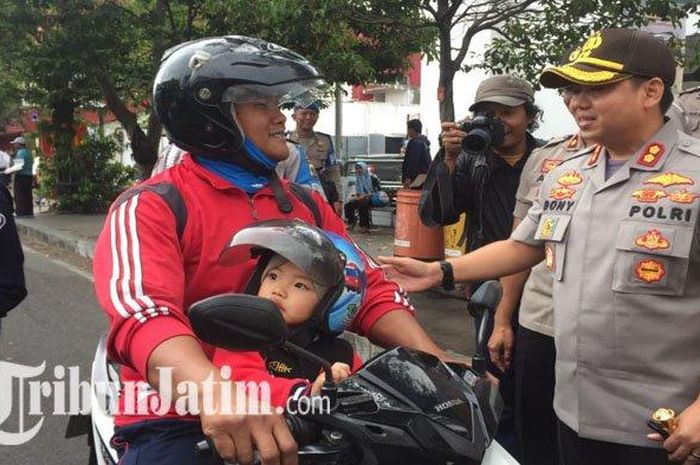 Kapolres Malang Kota AKBP Dony Alexander saat membagikan helm kepada pengendara motor di Pertigaan PLN Kayutangan, Kota Malang, Selasa (29/10/2019).