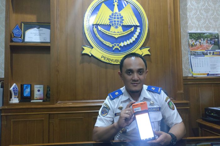 Henry Satya Negara menunjukkan alat E-Parkir