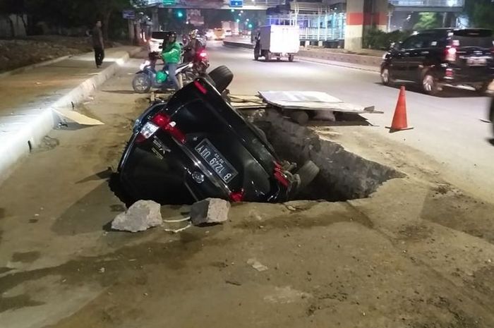 Mobil Xenia B 1249 UIY terperosok ke dalam lubanh galian di Jalan DI Panjaitan, Jakarta Timur, Senin (25/11/2019) pagi.
