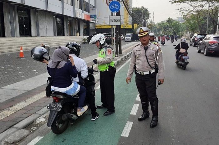 Polisi tindak pelanggar marka jalur sepeda.