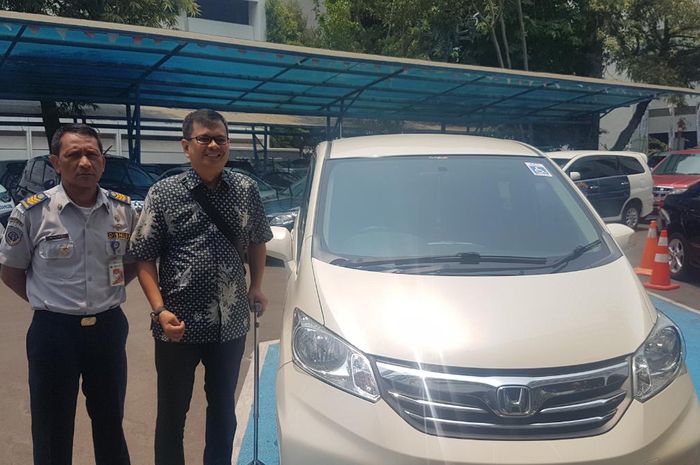 Arie Kurniawan (kanan) bersama petugas Dishub DKI Jakarta