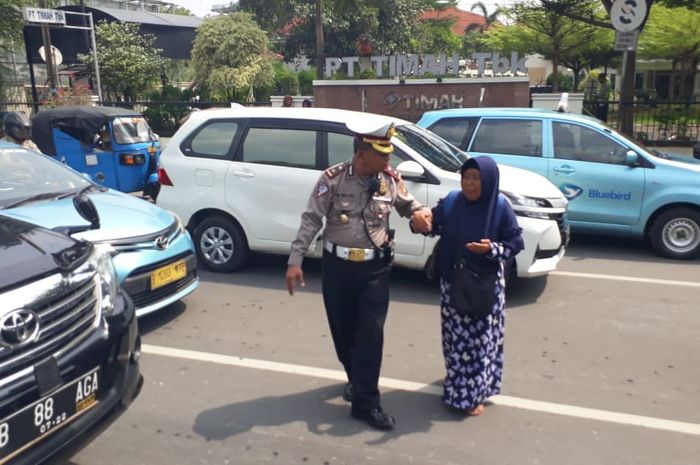 Kasi Gar Ditlantas Polda Metro Jaya Kompol Tri Waluyo saat menuntun wanita lansia menyebrang jalan