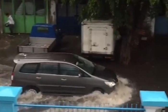 Kijang Innova melibas genangan air di salah satu ruas jalan di Jakarta Barat