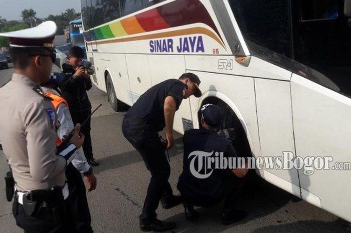 Petugas melakukan pemeriksaan kelaikan terhadap bus yang hendak melintas di Tol Jagorawai