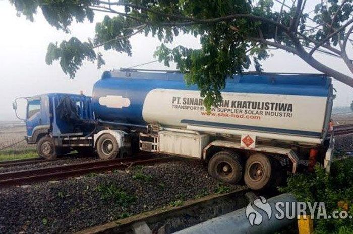 Truk tangki yang melintang di atas rel kereta api (double track）di Lamongan, Rabu (25/12/2019). 