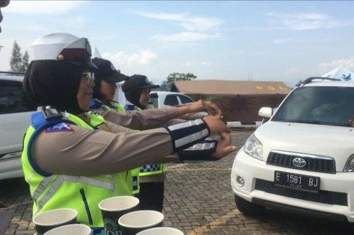 Beberapa anggota kepolisian membagikan kopi dan mengajak berolahraga kepada para pemudik di rest area KM 166 Tol Cipali, Rabu (25/12/2019)