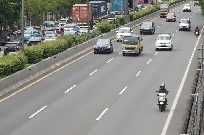 Pemotor melintasi jalan tol Jakarta - Merak akibat banjir yang menggenangi wilayah Ciledug hingga Kebon Jeruk