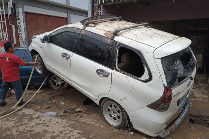 Toyota Avanza terseret banjir di Perum Pondok Gede Permai.