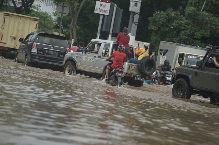 Mobil dan motor melintasi banjir yang masih menggenangi ruas Jalan Panjang