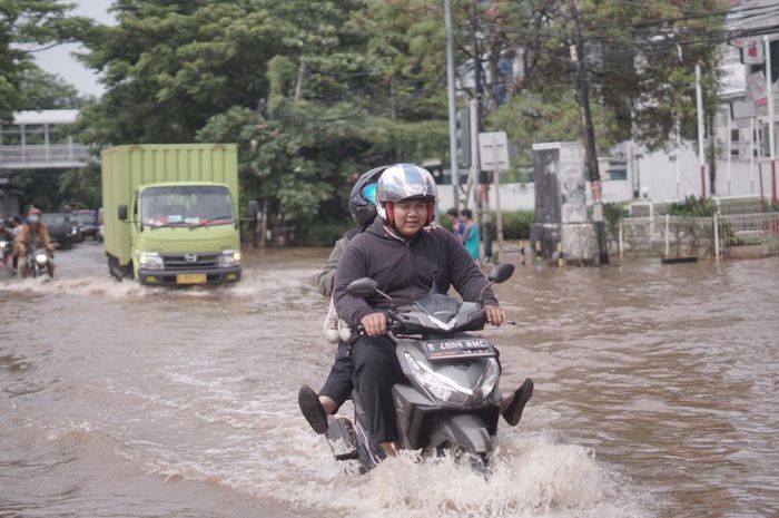 Melintasi banjir pakai motor