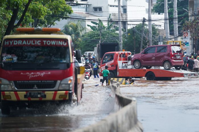 Sebuah mobil terlihat ditowing melintasi banjir di Green Garden