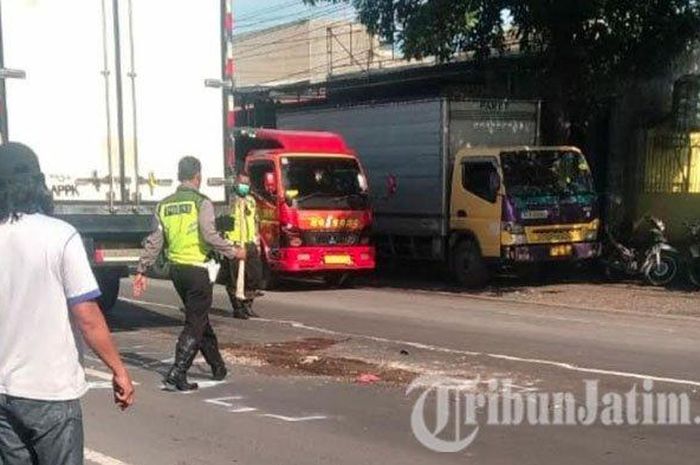 Polisi Laka Lantas Polresta Mojokerto mengevakuasi pemotor yang tewas dilindas dump truk di jalan Raya Mojosari Kabupaten Mojokerto, Senin (6/1/2020).