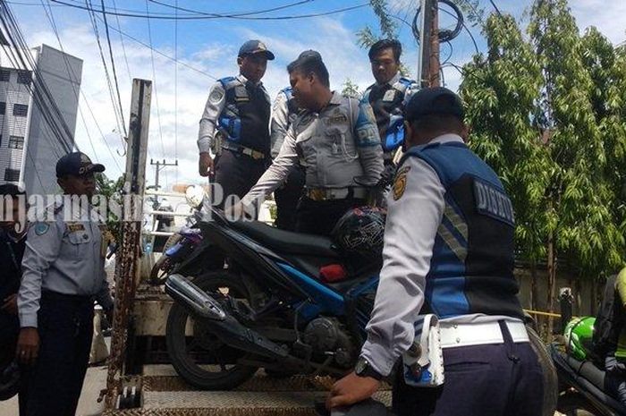 Petugas Dishub Kota Banjarmasin mengangkut motor yang parkir sembarangan di Jalan Simpang Ulin, Banjarmasin ke atas truk, Senin (6/1)