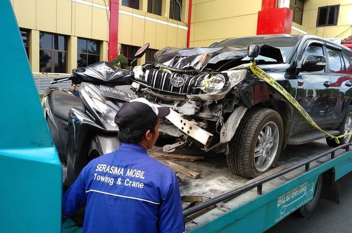 Seseorang melintas di depan mobil Prado milik Jamaludin dan sepeda motor Honda Vario yang dikendarai Reza saat membuang jasad korban ke Kutalimbaru, Deli Serdang. (KOMPAS.COM/DEWANTORO)