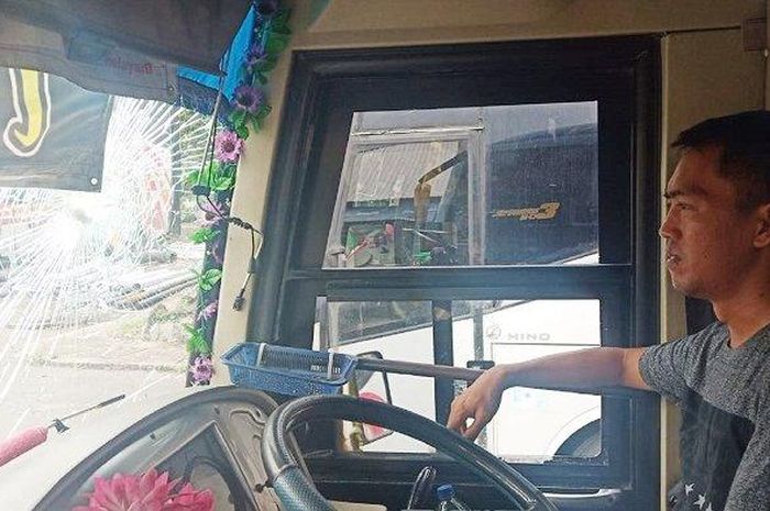 Sopir bus Sugeng Rahayu menunjukkan bagian yang rusak karena lemparan batu di Solo, Jumat (10/1/2020).  