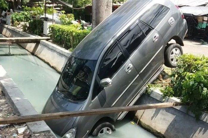 Toyota Kijang Innova terjungkal ke dalam selokan di Sunter Jaya, Tanjung Priok, Jakarta Utara