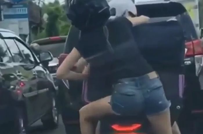 Seorang turis mencoba duduk di jok Honda PCX namun gagal