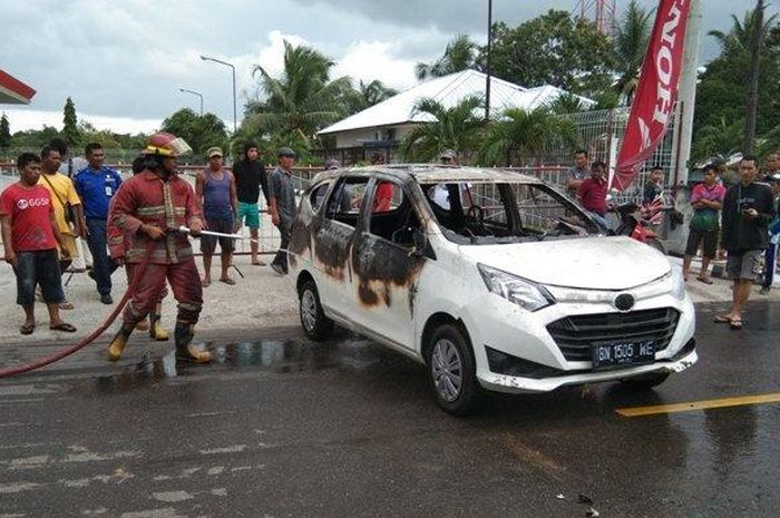 Petugas SPBU saat memadamkan mobil yang terbakar d idepan SPBU Jalan Pilang, Desa Dukong, Jumat (24/1/2020) 