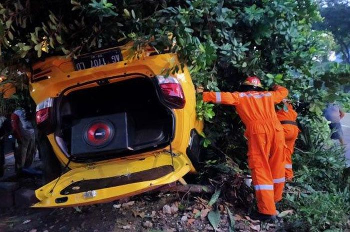 Petugas saat melakukan evakuasi terhadap mobil yang terlibat laka tunggal di Jalan Ir DR H Soekarno Surabaya  