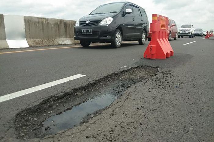 Ilustrasi jalan tol berlubang akibat genangan air hujan